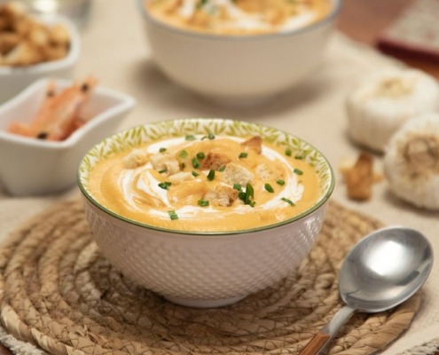 Crema de gambas al ajillo servida en cuenco, con aceite aromático y toque de perejil fresco