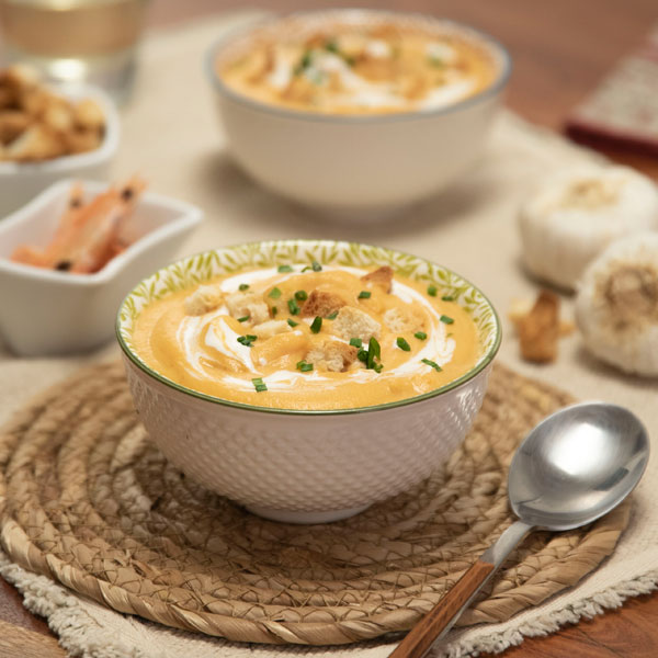Crema de gambas al ajillo servida en cuenco, con aceite aromático y toque de perejil fresco