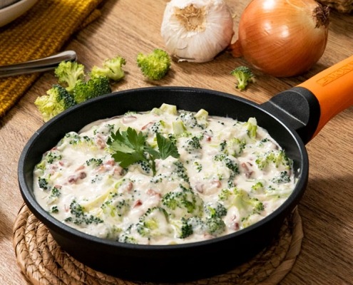 Brócoli con jamón en salsa cremosa, servido caliente en plato hondo