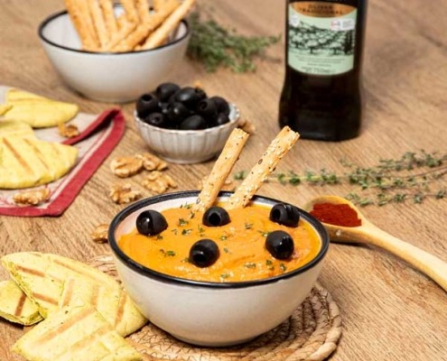Hummus de pimientos asados servido con pan de pita y un chorrito de aceite de oliva