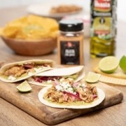 Tacos rellenos de carne mechada, servidos en tortillas con acompañamientos frescos