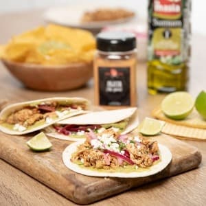 Tacos rellenos de carne mechada, servidos en tortillas con acompañamientos frescos
